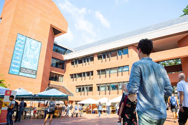 Male student walking across Red Square towards the ICC